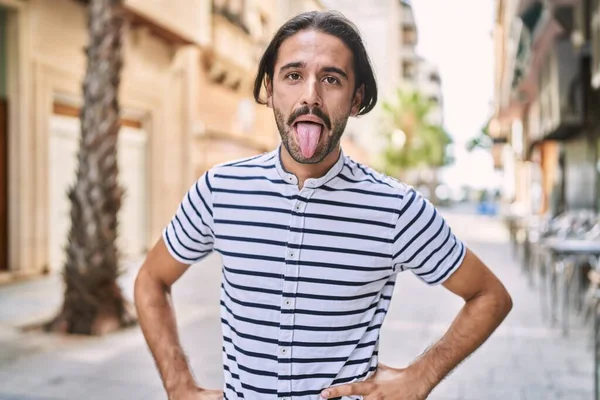 Young Hispanic Man Beard Outdoors City Sticking Tongue Out Happy — Stockfoto