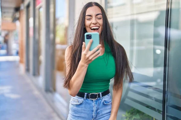 ストリートでの驚きの表情を持つスマートフォンを使用して若い美しいヒスパニック系女性 — ストック写真