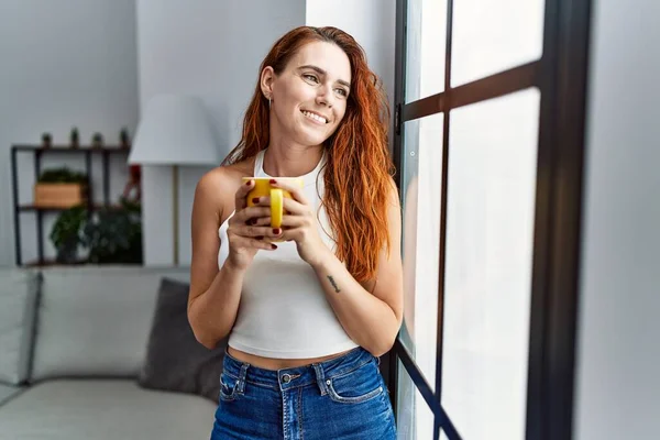 Jovem Ruiva Sorrindo Confiante Beber Café Casa — Fotografia de Stock