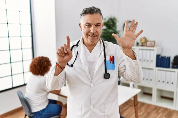 Lekarz Średnim Wieku Klinice Pacjentem Pokazującym Wskazującym Palcami Numer Sześć — Zdjęcie stockowe