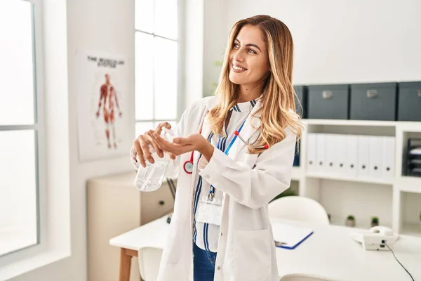 Young Blonde Woman Wearing Doctor Uniform Using Sanitizer Gel Hands — Φωτογραφία Αρχείου