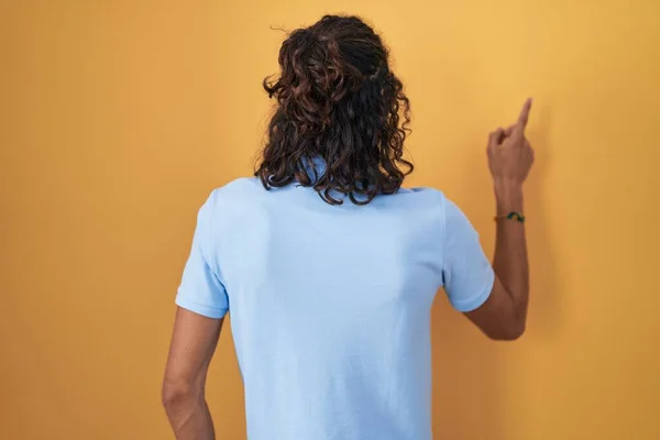 Young Hispanic Man Standing Yellow Background Posing Backwards Pointing Ahead — Stock Photo, Image