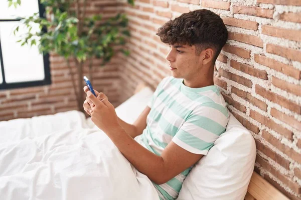 Latin Kökenli Genç Yatak Odasında Rahat Bir Ifadeyle Akıllı Telefon — Stok fotoğraf