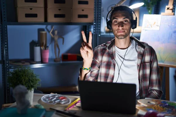 Joven Hombre Hispano Sentado Estudio Arte Con Portátil Tarde Noche —  Fotos de Stock