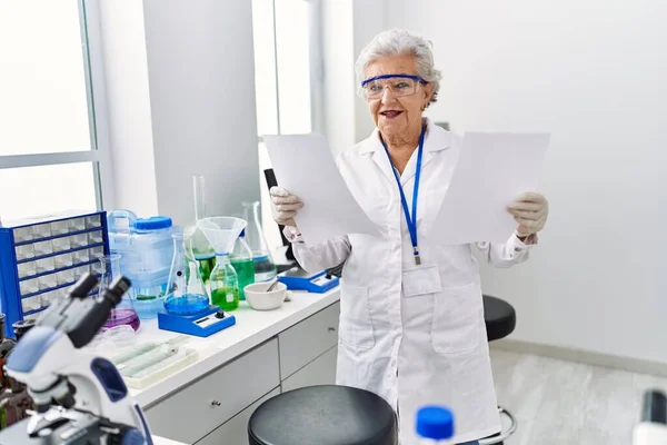 研究室で科学者の制服を着たシニア白髪の女性 — ストック写真