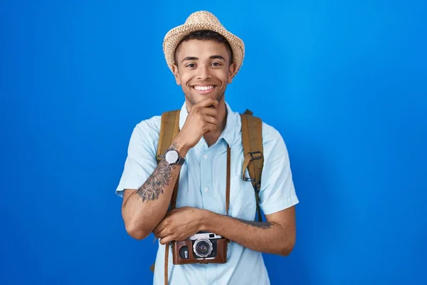 腕を交差させて笑顔でカメラを見て自信を持っているブラジルの若い男と手をあごに上げました ポジティブな — ストック写真