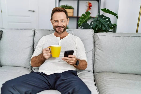 Homem Hispânico Meia Idade Usando Smartphone Bebendo Café Casa — Fotografia de Stock