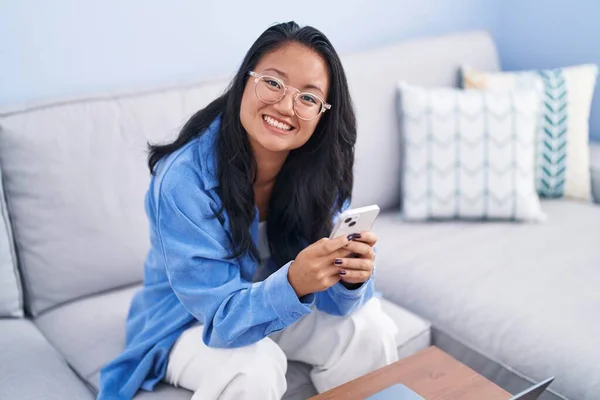 Young Chinese Woman Using Smartphone Sitting Sofa Home — Fotografia de Stock