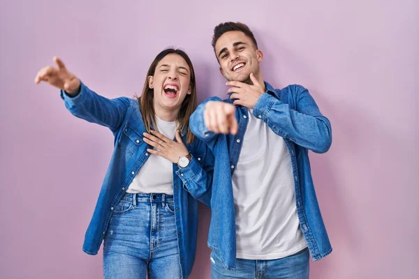 Young Hispanic Couple Standing Pink Background Laughing You Pointing Finger — Stockfoto