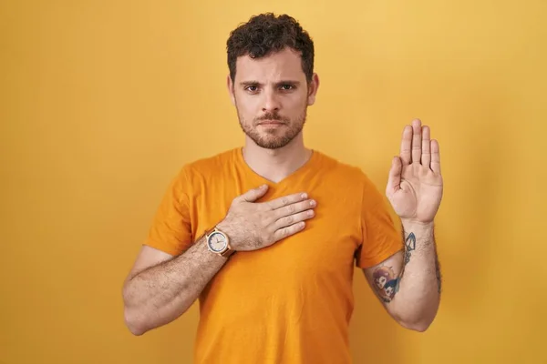 Young Hispanic Man Standing Yellow Background Swearing Hand Chest Open — Stock Photo, Image