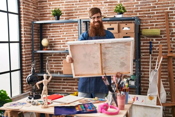 Young redhead man artist smiling confident looking draw at art studio