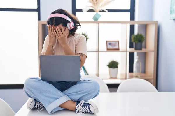 Young Hispanic Woman Using Laptop Sitting Table Wearing Headphones Sad —  Fotos de Stock
