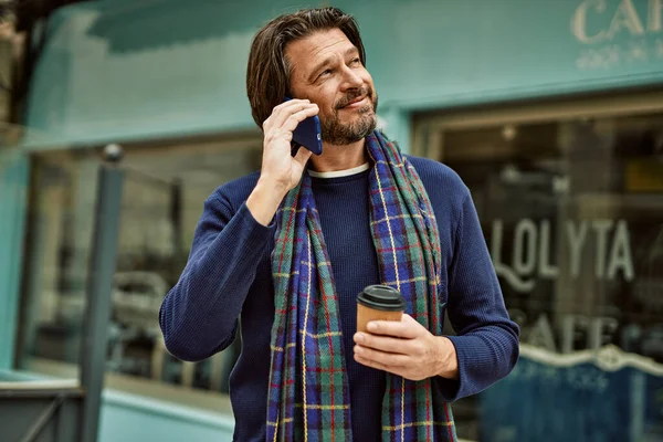 Middle age handsome man speaking on the phone at the town