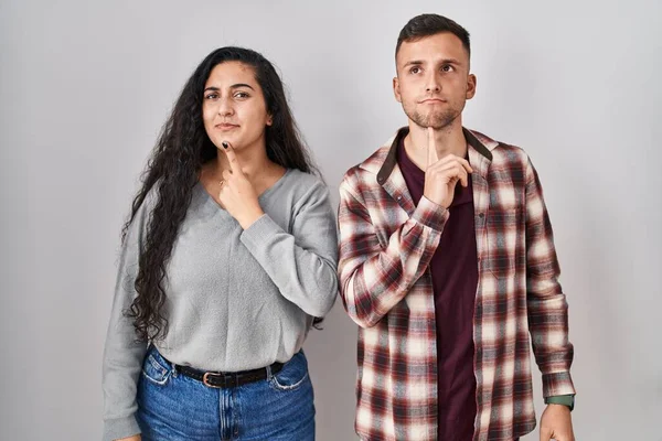 Jong Hispanic Paar Staan Witte Achtergrond Denken Geconcentreerd Twijfel Met — Stockfoto