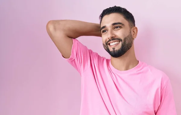 Spaanse Jongeman Staat Roze Achtergrond Glimlachend Zelfverzekerd Aanraken Van Haar — Stockfoto