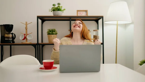 Νεαρή Κοκκινομάλλα Γυναίκα Χρησιμοποιώντας Φορητό Υπολογιστή Γιορτάσουν Έκφραση Στο Σπίτι — Φωτογραφία Αρχείου