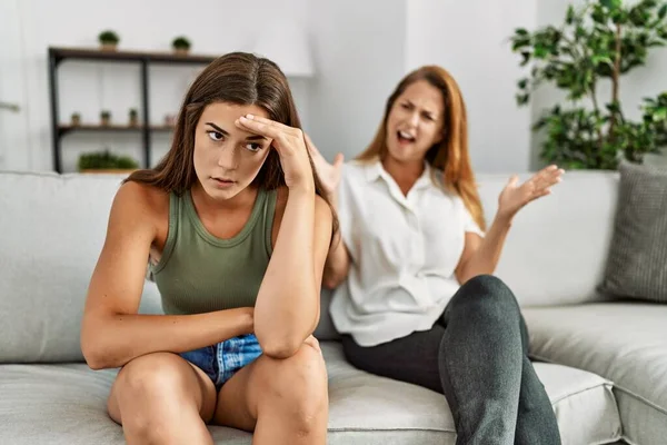 母亲和女儿坐在家里的沙发上不愉快地争论着 — 图库照片