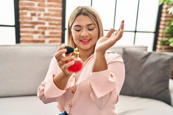 Giovane Donna Ispanica Utilizzando Profumo Seduto Sul Divano Casa — Foto Stock