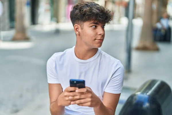 Joven Adolescente Hispano Usando Smartphone Con Expresión Relajada Calle —  Fotos de Stock