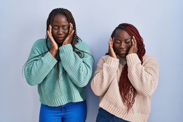 ストレスのために頭の上に手で青の背景に立って2人のアフリカ人女性 片頭痛 — ストック写真