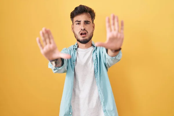 Young Hispanic Man Tattoos Standing Yellow Background Doing Stop Gesture — стоковое фото