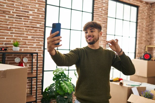 Young arab man make selfie by smartphone holding key at new home