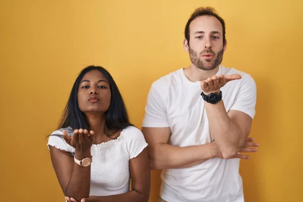 Interracial Couple Standing Yellow Background Looking Camera Blowing Kiss Hand — Foto Stock