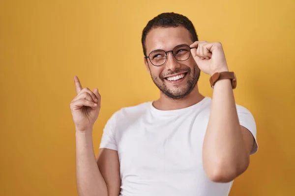 Hispánec Drží Brýle Šťastně Ukazuje Rukou Prstem Stranu — Stock fotografie