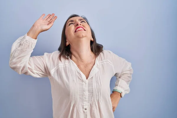 Middelbare Leeftijd Spaanse Vrouw Die Een Blauwe Achtergrond Die Zich — Stockfoto