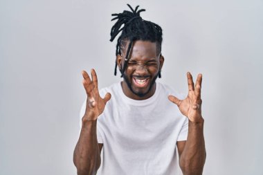 Beyaz arka plan üzerine günlük tişört giyen Afrikalı adam kollarını kaldırmış ve gözleri kapalı heyecanla haykırarak başarının çılgınlığını kutluyor. Kazanan konsept 