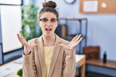 Ofiste çalışan genç kız gözlüklü deli deli deli deli bağırıyor ve agresif bir ifade ve kollarıyla bağırıyor. hüsran kavramı. 