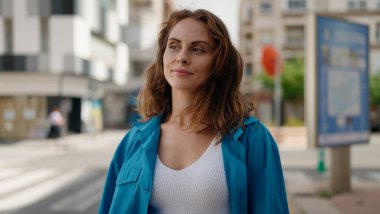 Sokakta duran rahat yüzlü genç kadın.