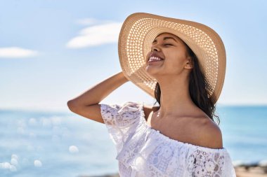 Genç Afrikalı Amerikalı turist. Deniz kenarında kendine güvenen yaz şapkası takıyor.