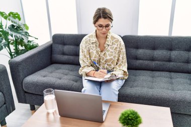 Young hispanic woman having pshychology teleconsultation at psychology clinic