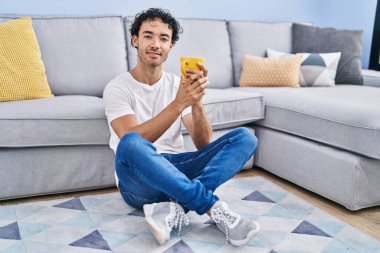 Genç İspanyol adam evde oturmuş kahve içiyor.