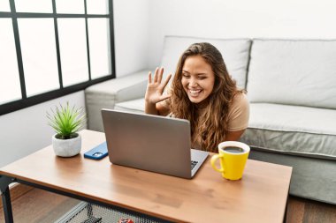 Genç, güzel, İspanyol bir kadın evde oturmuş video görüşmesi yapıyor.