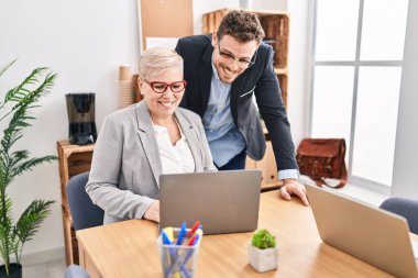 Mother and son business workers using laptop working at office