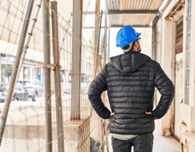 Young man architect standing on back view at street
