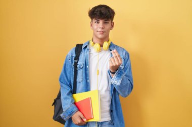 İspanyol ergen öğrenci çantası takıyor ve elinde kitaplarla el kol hareketi yapıyor. Maaş istiyor, milyonerlik işi istiyor. 