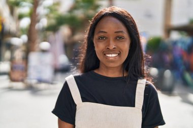 Genç Afrikalı Amerikalı kadın gülümsüyor. Kendine güveni tam.