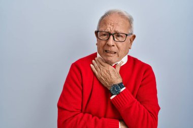 Senior man with grey hair standing over isolated background shouting suffocate because painful strangle. health problem. asphyxiate and suicide concept. 