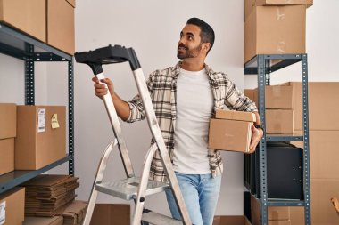 İspanyol asıllı genç bir iş adamı ofiste paketleri tutuyor.