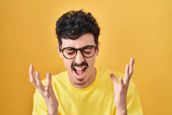 Hispanic Man Wearing Glasses Standing Yellow Background Celebrating Mad Crazy — ストック写真