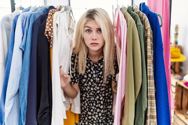 Young Blonde Woman Searching Clothes Clothing Rack Skeptic Nervous Frowning — Stockfoto