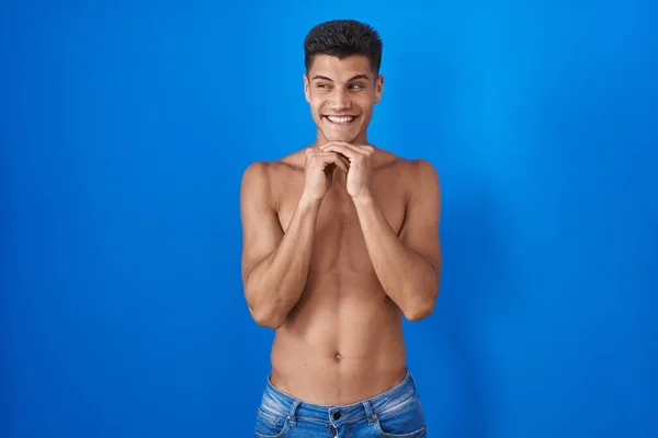 Joven Hombre Hispano Pie Sin Camisa Sobre Fondo Azul Riendo —  Fotos de Stock