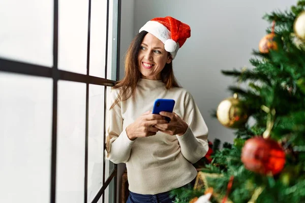 Middelbare Leeftijd Spaanse Vrouw Met Behulp Van Smartphone Stand Kerstboom — Stockfoto