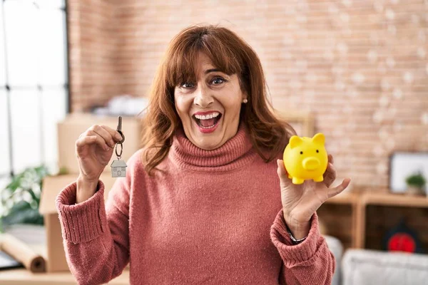 Middle Age Hispanic Woman Holding Piggy Bank House Keys Smiling — Stockfoto