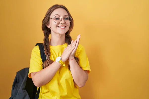 Jovem Caucasiana Vestindo Mochila Estudantil Sobre Fundo Amarelo Batendo Palmas — Fotografia de Stock