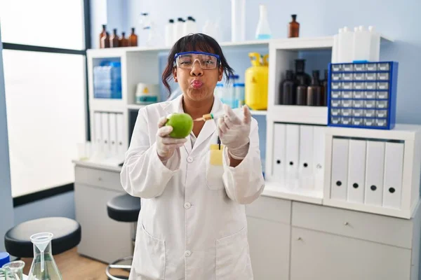 Hispanic Woman Working Scientist Laboratory Apple Puffing Cheeks Funny Face — Stockfoto