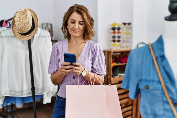 Middelbare Leeftijd Spaanse Vrouw Met Behulp Van Smartphone Winkelen Kledingwinkel — Stockfoto